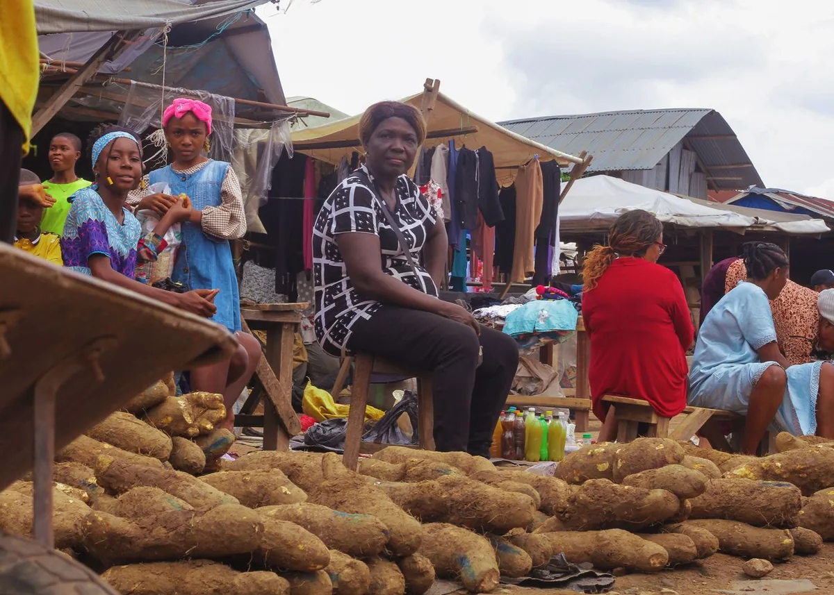 Des vendeuses installées derrière leurs étals de tubercules sur un marché africain